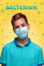 The concept of protection against viruses and diseases. A teenage boy in a blue t-shirt and mask stands on a yellow background Royalty Free Stock Photo