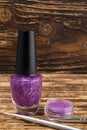 Concept in purple for nail decoration during manicure in the salon, burnt wooden background