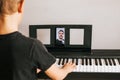 CHILD LEARNS TO PLAY THE PIANO ONLINE Royalty Free Stock Photo