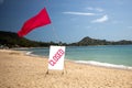 Concept quarantine, pandemic, coronavirus, stay home. tropical beach on a sunny day without people. there is a red flag Royalty Free Stock Photo