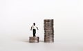 The concept of racial wage discrimination. A miniature black man standing on a low pile of coins. Royalty Free Stock Photo