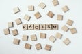 Concept of racism and misunderstanding between people, prejudice and discrimination. Wooden block with word racism on the white