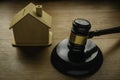 Concept of real estate auction, legal system and property division after divorce. Gavel and house toys on a wooden background Royalty Free Stock Photo