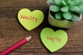Concept of Reality or Myth write on sticky notes isolated on Wooden Table