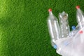 The concept of recycling plastic and environmental protection. Pet preforms for plastic bottles on the green grass. Artificial