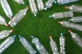 The concept of recycling plastic and environmental protection. Pet preforms for plastic bottles on the green grass. Artificial