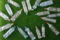 The concept of recycling plastic and environmental protection. Pet preforms for plastic bottles on the green grass. Artificial