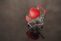 A red heart lies in a shopping cart