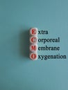 Concept red words \'ECMO, Extra Corporeal Membrane Oxygenation\' on wooden cubes on a beautiful blue background