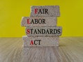 Concept red words FLSA - fair labor standards act on wooden cubes on a beautiful blue background. Business concept. Royalty Free Stock Photo