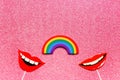 Concept of relationship between women, flatlay false photo stand props lips rainbow on pink shiny background copy space