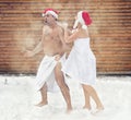 Man and woman refresh in snow after hot sauna.Concept of: relax, vacation,healthy lifestyle.