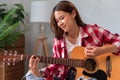 Concept of relaxation with music, Young asian woman practice playing chords with acoustic guitar Royalty Free Stock Photo