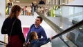 Concept of relaxing family. Father, mother and daughter on escalator