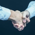 Concept of a reliable partnership: a close-up of handshake of business partners on a black background. Royalty Free Stock Photo