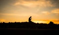 Concept of religion Islam. Silhouette of man praying on the background of a mosque at sunset