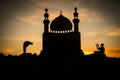 Concept of religion Islam. Silhouette of man praying on the background of a mosque at sunset