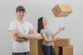 Strong delivery man transported boxes into new apartment of lovely young woman and is standing on the forefront, his Royalty Free Stock Photo