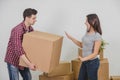 Couple in a new flat. Young man is totaly exhausted. He can not hold heavy box anymore.