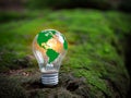 Concept of renewable energy, environmental protection, and sustainable renewable energy sources. Green world map on a light bulb Royalty Free Stock Photo