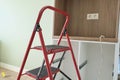 Concept of repair, manufacturing and installation of furniture, stepladder in interior