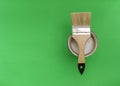 Concept of repair, painting of furniture and premises. Paintbrush on a can of paint, bright green background, top view. Copyspace Royalty Free Stock Photo