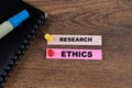 Concept of Research Ethics write on sticky notes isolated on Wooden Table