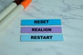 Concept of Reset, Realign, Restart write on sticky notes isolated on Wooden Table Royalty Free Stock Photo
