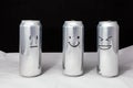 Concept of ridicule. Joke over a friend but it`s not funny to him. Aluminium cans with drowing emoticons. Emoji of laugh, smile Royalty Free Stock Photo