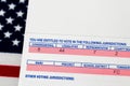 Closeup of voter registration identification card with American flag in background