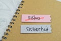 Concept of Risiko or Sicherheit write on sticky notes isolated on Wooden Table