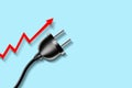 Concept, rising electricity prices. Electric plug, and a red up arrow, on a blue background. copy space. World energy crisis.3D