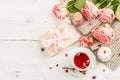 The concept of romantic tea. Wrapped gift, hibiscus tea, a bouquet of delicate roses, sweets Royalty Free Stock Photo