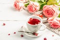 The concept of romantic tea. Wrapped gift, hibiscus tea, a bouquet of delicate roses, sweets Royalty Free Stock Photo