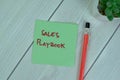 Concept of Sales Playbook write on sticky notes isolated on Wooden Table