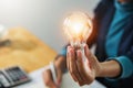 concept save energy power. businesswoman holding light bulb in office Royalty Free Stock Photo