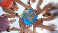 The concept of saving the world. A group of friends hold the world globe in their hands. Royalty Free Stock Photo