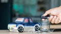 Concept of savings and financial planning of car leasing. Man`s hand holding car key over a glass jar, Business, finance or budge