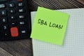 Concept of SBA Loan write on sticky notes with calculator isolated on Wooden Table Royalty Free Stock Photo