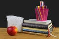 Concept of school lunch break with apple and school supplies on wooden desk, selective focus. Books, markers and color Royalty Free Stock Photo