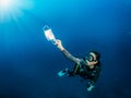 A scuba diver who picks up a used face mask underwater