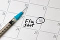 Flu shot reminder on calendar with needle syringe