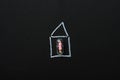 The concept of self-isolation and protection against viruses at home. Figurine of a woman in a capsule in a house drawn on a black