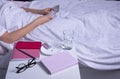 Concept of self-isolation of sick person at home.Sick girl holds pills in  hands. Bedside table with notebook, glasses and glass Royalty Free Stock Photo