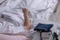 Concept of self-isolation of sick person at home. Tonometer on the bedside table. Girl squeezes blanket with hand