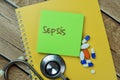 Concept of Sepsis write on sticky notes with stethoscope isolated on Wooden Table