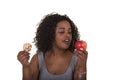 Concept shoot about health care of a woman choosing between an apple and a cookie Royalty Free Stock Photo