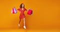 Concept of shopping purchases and sales of happy   girl with packages  on yellow background Royalty Free Stock Photo