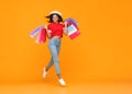 Concept of shopping purchases and sales of happy   girl with packages  on yellow background Royalty Free Stock Photo