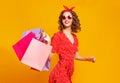 Concept of shopping purchases and sales of happy young girl with packages  on yellow background Royalty Free Stock Photo